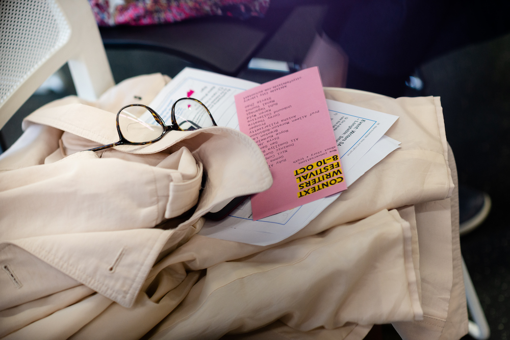 Context festival program on a set with glasses and a jacket