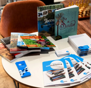 Several books on a table along with bookmarks and brochures